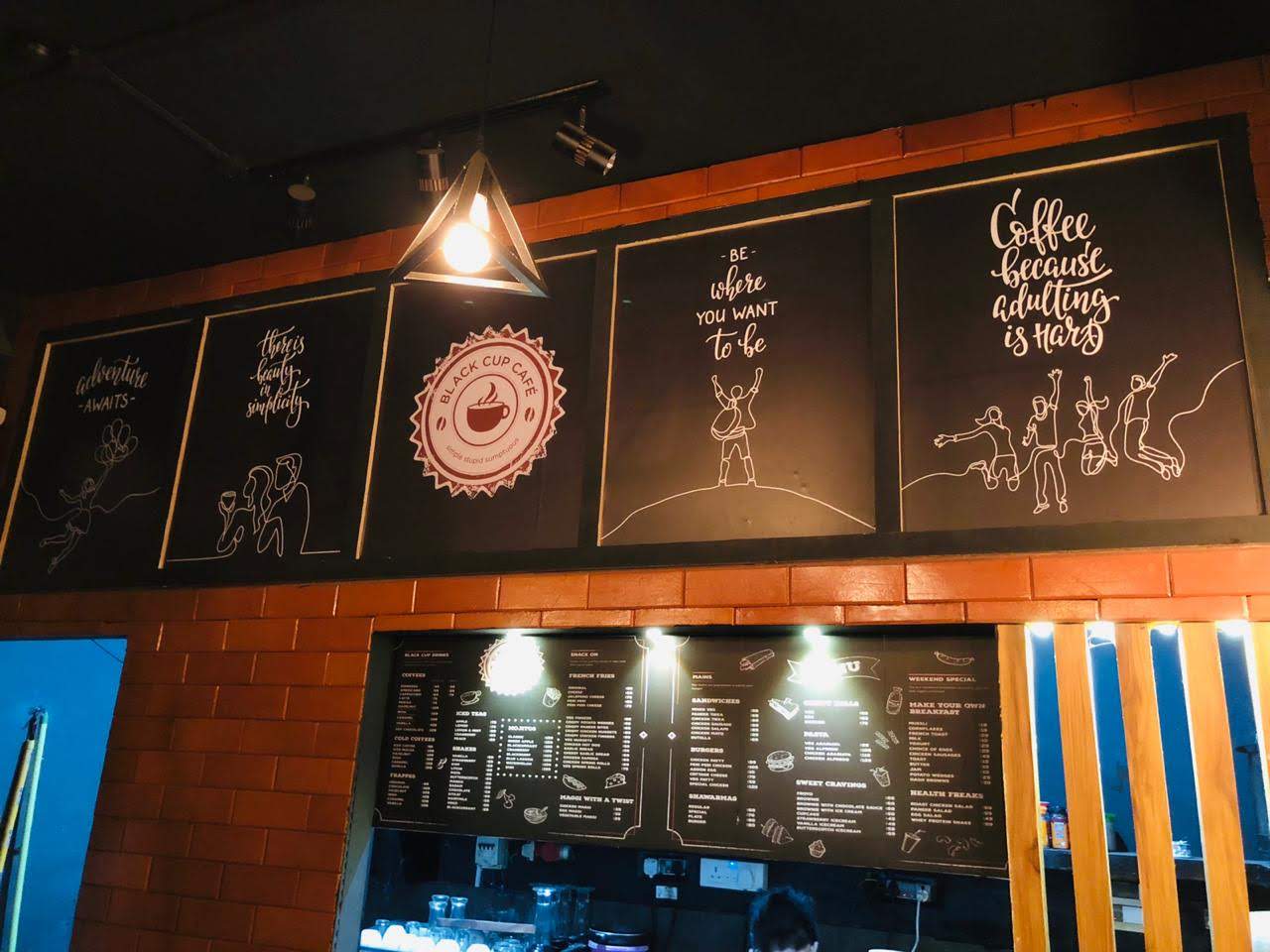 Black Cup Café interior showing wall art installation above the counter